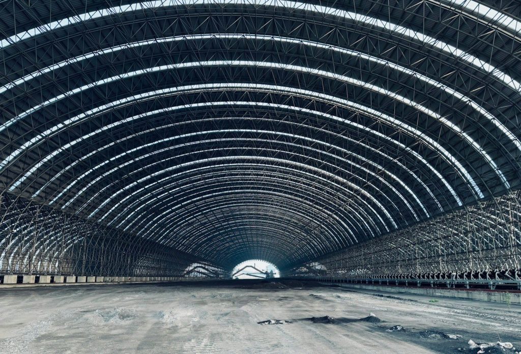 Vast industrial warehouse interior with arched metal ceiling